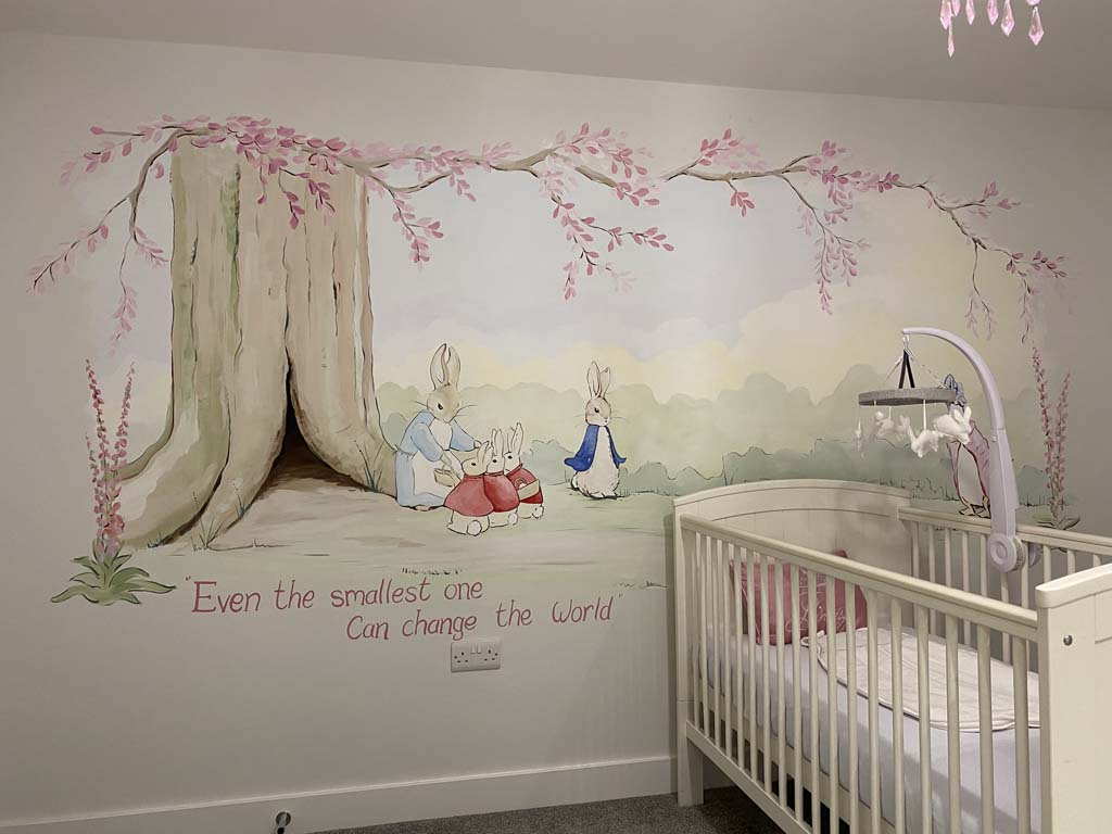 photo of room with baby's cot Infront of wall with a Peter Rabbit nursery wall mural with Quote