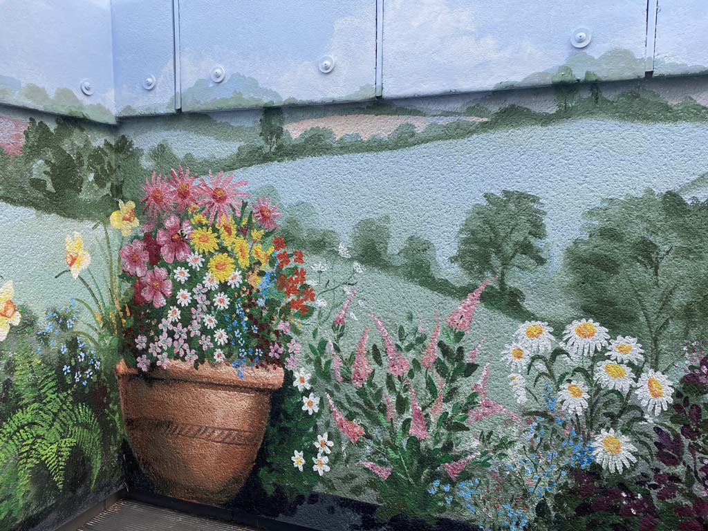 Balcony Mural with plant pot, hills and flowers painted by artist.